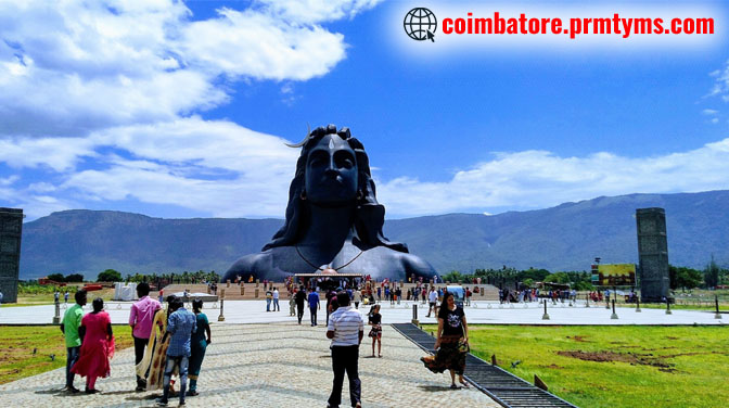 Adiyogi Shiva statue at Isha Yoga Center in Coimbatore with a crowd of visitors and cloudy sky in the background